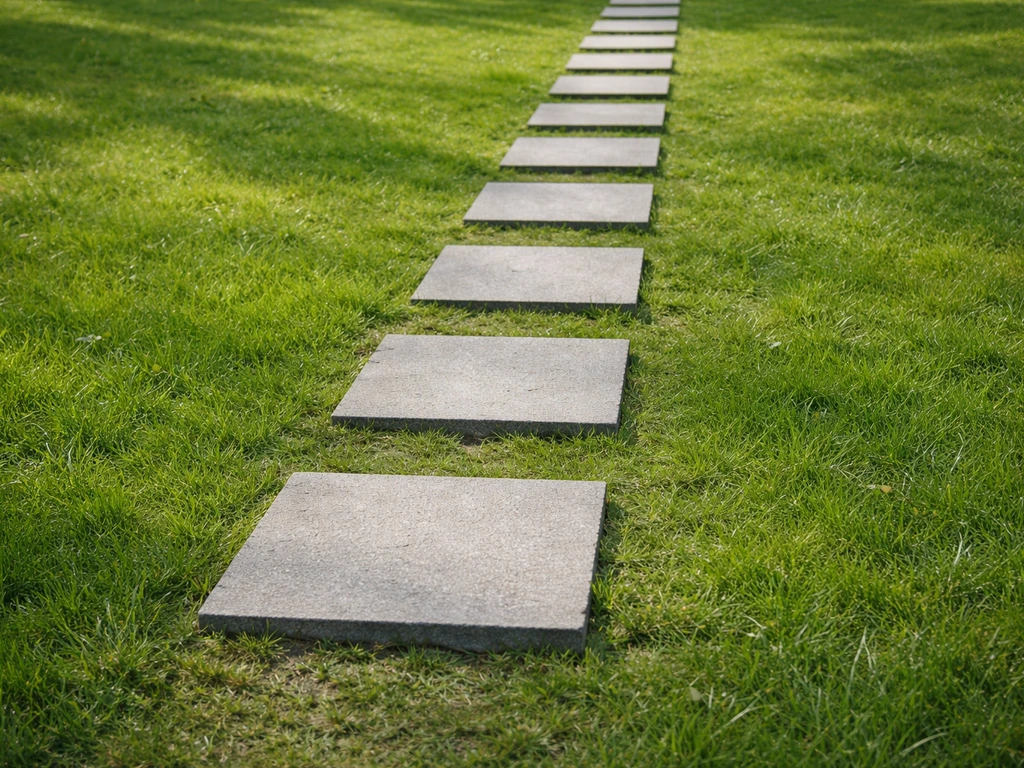Nette staptegels in een groen gazonpad met natuurlijke plaatsing en zicht op een rustige looproute.